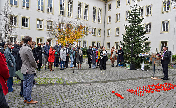 Abgeordnete und Besucher stehen im Halbrund im Innenhof des Landtags