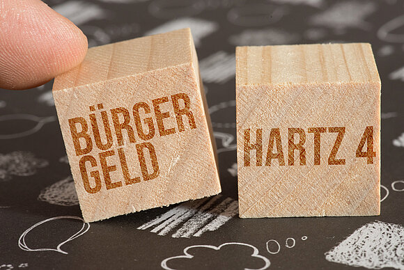 Bürgerld versus Hartz IV, hier symbolisiert durch zwei gegeneinander auszuspielende Würfel.