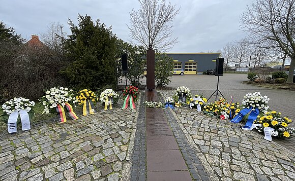 Blick auf die Kränze am Mahnmal MAGDA.