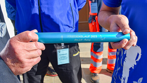 Der Staffelstab des diesjährigen Friedenslauf mit der Aufschrift Friedenslauf 2023, Bitterfeld–Hamburg.