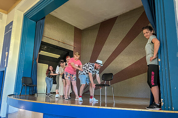 ltlsa/stb Menschen spielen eine Szene auf einer Theaterbühne