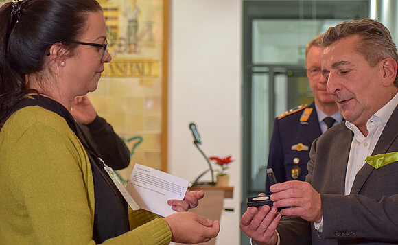 Landtagspräsident überreicht Medaille an Mutter eines Soldaten.