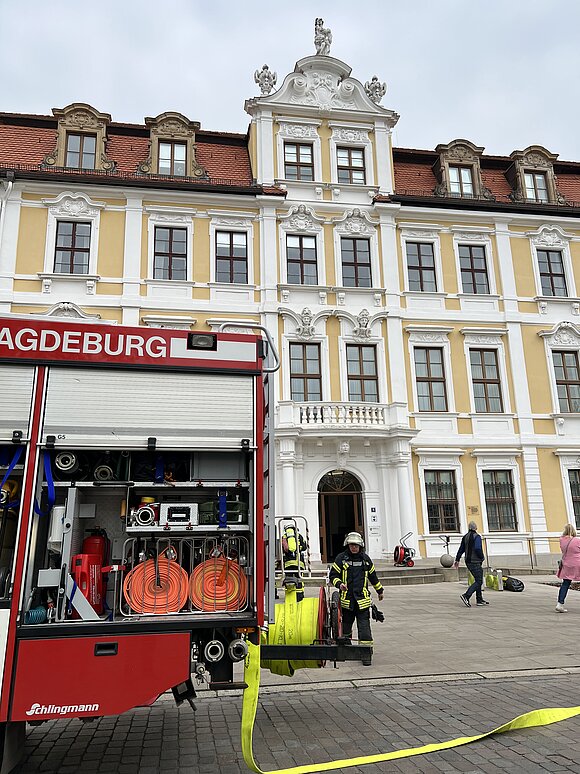 Feuerwehrauto und Feuerwehrmänner vor dem Landtag von Sachsen-Anhalt.