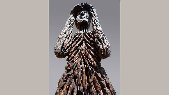 Eine mit der Kettensäge geschaffene Holzskulptur eines Menschen.