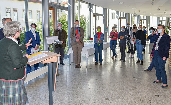 Blick in den Ausstellungsflur. Vorn spricht Vizepräsidentin Keding am Rednerpult, hinten stehen die Gäste.