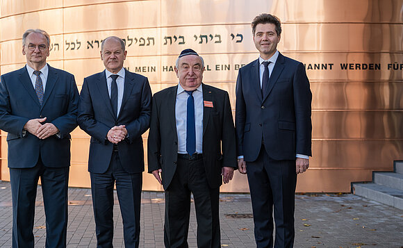 Ministerpräsident Dr. Reiner Haseloff, Bundeskanzler Olaf Scholz, der Vorsitzende der jüdischen Gemeinde Dessau Alexander Wassermann und Dessau-Roßlaus Oberbürgermeister Robert Reck vor der neuen Synagoge.