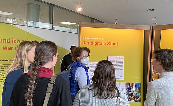 Besucher schauen sich Tafeln der Ausstellung an.