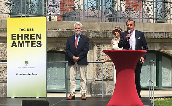 ltlsa/gri Landtagspräsident Schellenberger steht auf Bühne und spricht, daneben steht Minister Willingmann.