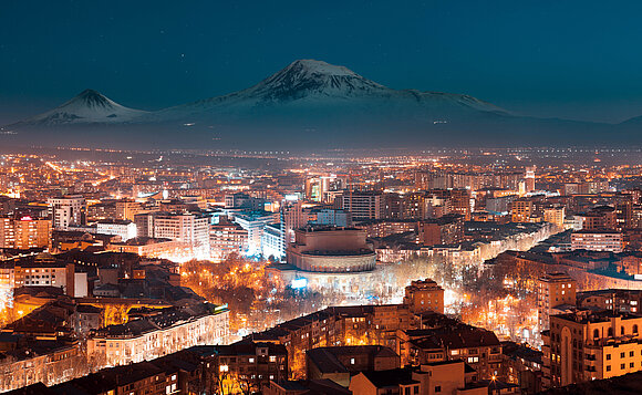 Nacht in Jerewan, hellerleuchtete Stadt unter dunklem Himmel.