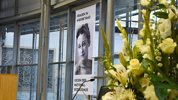 Blumen und Plakat bei der Gedenkveranstaltung am Holocaustgedenktag im Landtag von Sachsen-Anhalt.