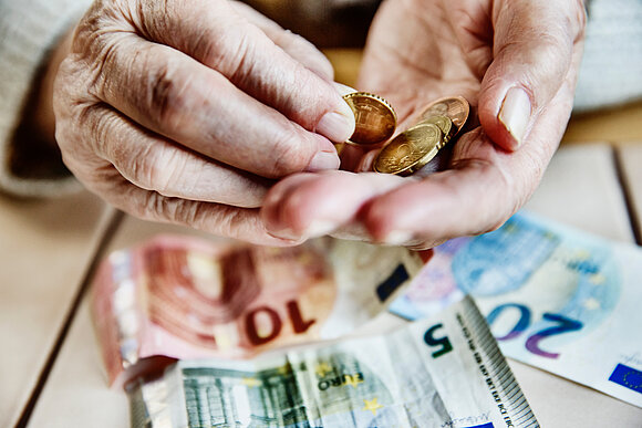 Eine Rentnerin zählt das wenige ihr zur Verfügung stehende Geld.
