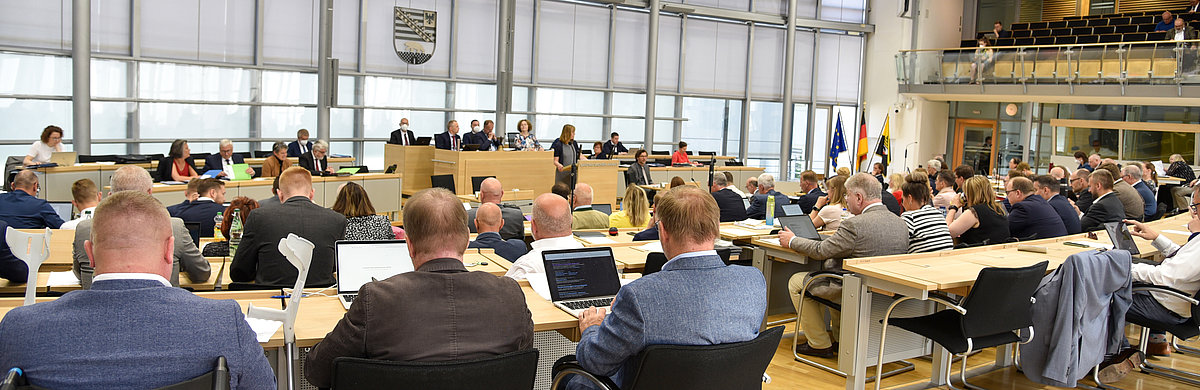 Blick aus den Reihen der Abgeordneten auf das Rednerpult im Plenarsaal