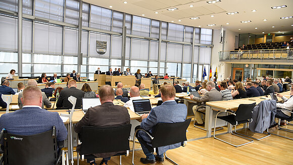 Blick aus den Reihen der Abgeordneten auf das Rednerpult im Plenarsaal