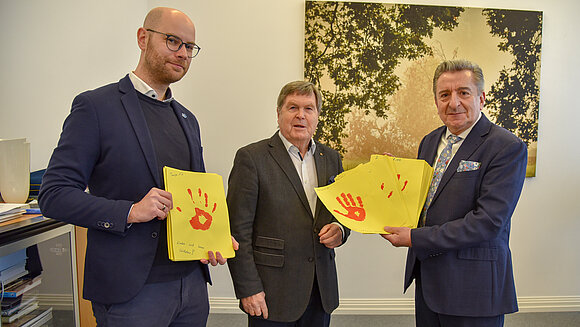 Landtagspräsident Dr. Gunnar Schellenberger (r.) nahm vom Volksbund-Vorsitzenden in Sachsen-Anhalt, Dieter Steinecke (M.), und von Volksbund-Bildungsreferent Philipp Schinschke die gesammelten roten Handabdrücke entgegen.