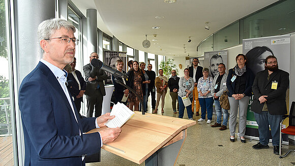 ltlsa/stb Redner im Vordergrund an Pult spricht zu Menschen im Hintergrund
